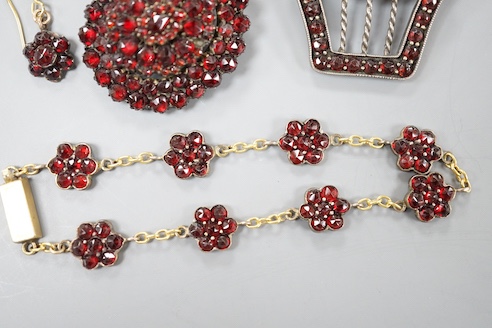 A Victorian gilt metal and facetted garnet set cluster brooch, 27mm, two other similar brooches, a bracelet and pair of earrings.